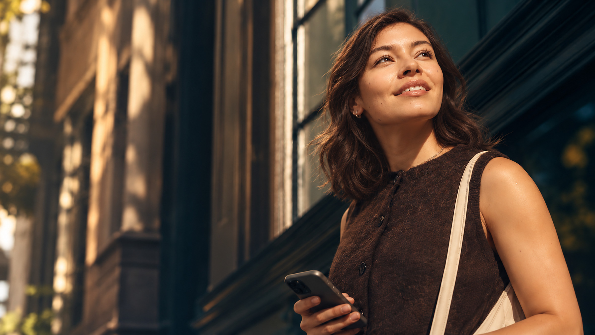 Paciente sonriendo al aire libre mientras revisa su teléfono